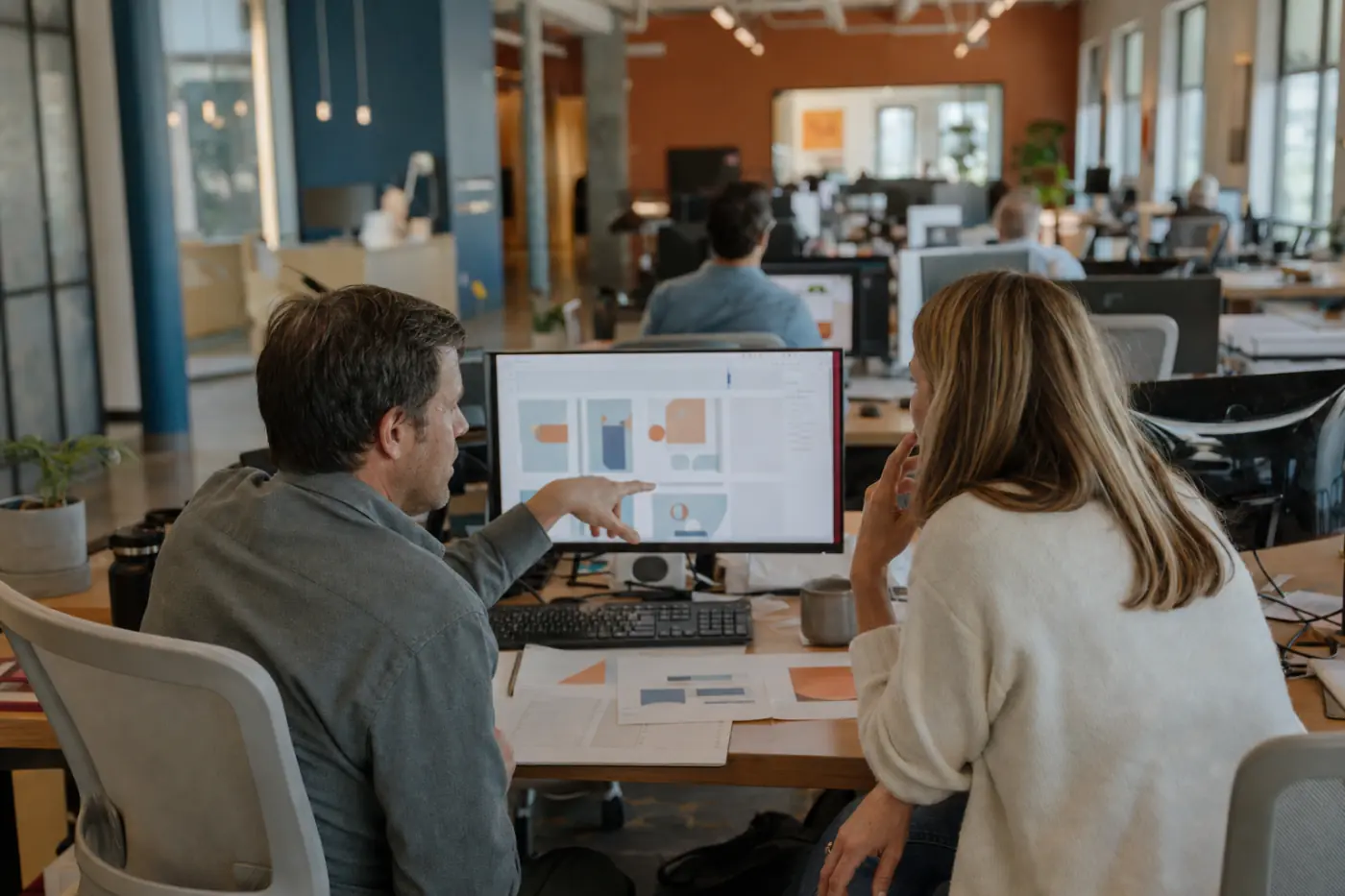 A digital content engineering floor, colleagues at workstations across a wide bright room