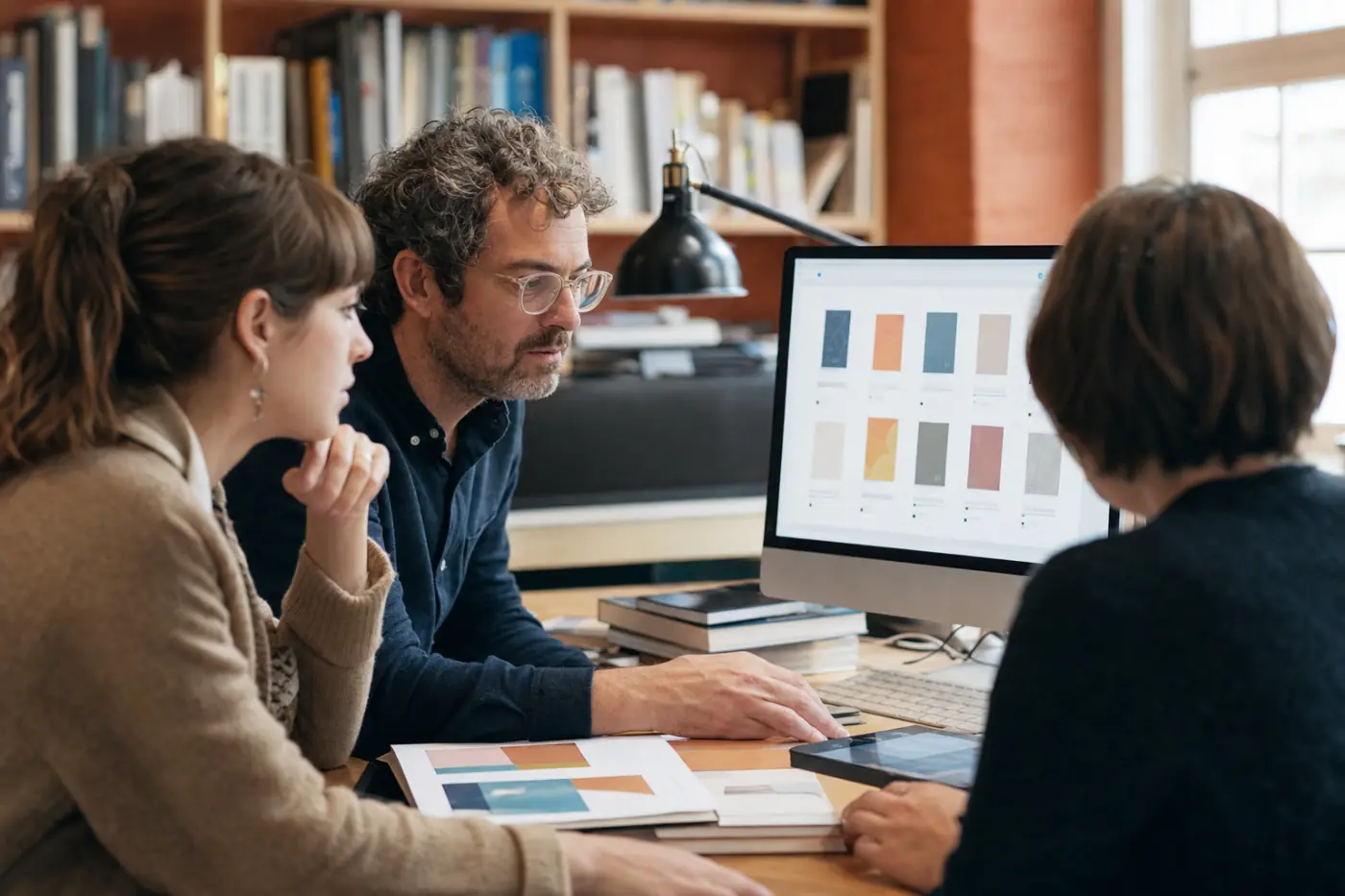 A publishing operations team reviewing a title list on a shared monitor