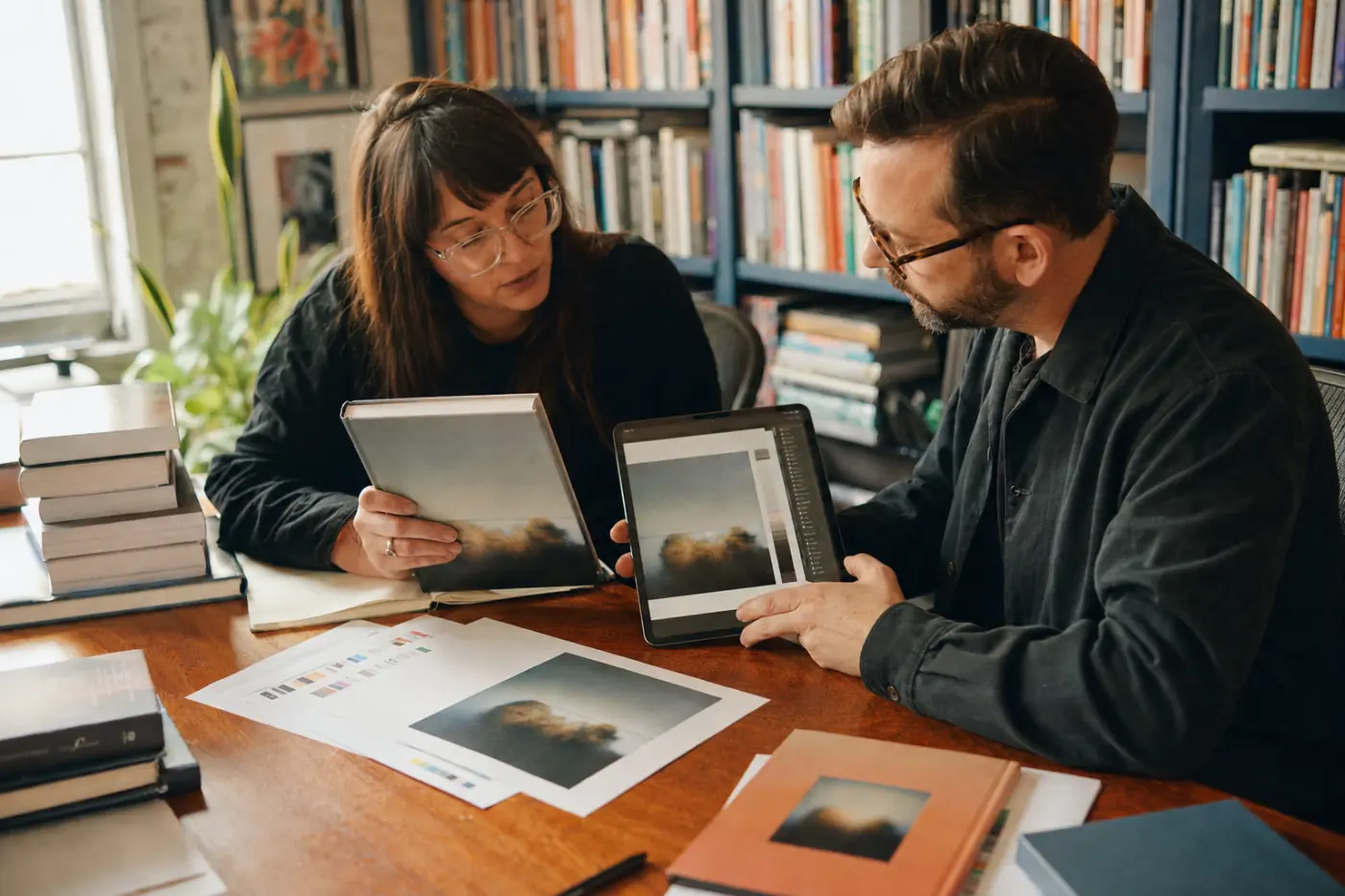 A publishing team reviewing a printed book and its digital edition